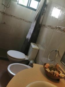 a bathroom with a toilet and a sink and a table at Atlantic 10 in Atlántida