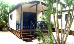 a wooden decked house with a porch and a balcony at Coral Coast Tourist Park in Townsville