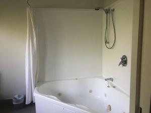 eine weiße Badewanne im Bad mit Dusche in der Unterkunft Claremonte Motor Lodge in Hastings