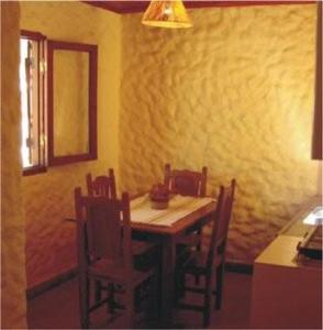 ein Esszimmer mit einem Holztisch und Stühlen in der Unterkunft Cabañas Achalay in Santa María
