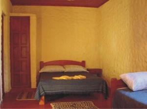 1 dormitorio con 1 cama en una habitación amarilla en Cabañas Achalay en Santa María