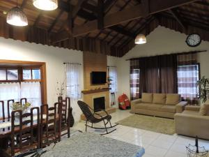 a living room with a couch and a table at Chalé Sonho Meu in Monte Verde