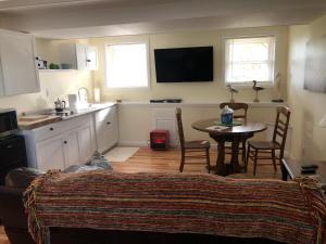 a living room with a table and a kitchen at 14 Charles St Apartment in Guilford