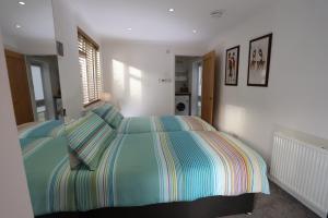 a bedroom with a bed with a striped comforter at Tweedbank in Galashiels