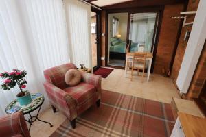 a living room with a couch and a chair at Tweedbank in Galashiels