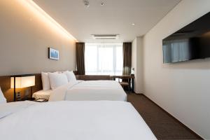 Postel nebo postele na pokoji v ubytování Ramada Encore by Wyndham Busan Haeundae