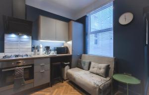 a kitchen with a couch in the corner of a room at Yellow Hive Boutique Stay Apt 1 in Belfast