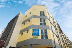a yellow and white building with a sign on it at ibis budget Singapore Imperial in Singapore