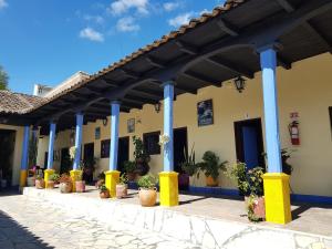 a building with blue columns and potted plants on it at Hotel Lirice Colonial in Comitán