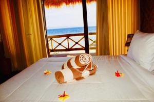 a hotel room with a bed with a hat and shoes on it at Pondok Bamboo Villa in Nusa Penida