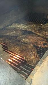 un montón de carne cocinando en una parrilla en La famosa costillas a la leña, en Jarabacoa