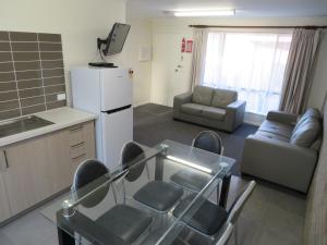 a living room filled with furniture and a tv at Warrnambool Motel and Holiday Park in Warrnambool