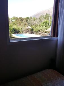 ventana en una habitación con vistas a la piscina en Pa-kuas del Uritorco en Capilla del Monte