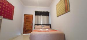 um quarto com uma cama com um bicho de peluche em Elisa Homestay Areguling em Kuta