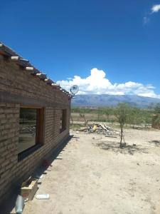 a building in the desert with a satellite at Camping agreste El Algarrobo de Quilmes in Amaicha del Valle