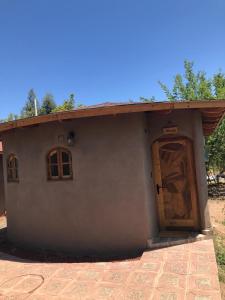 Cabañas Terra Pocuro في لوس أوديس: منزل صغير فيه باب ونافذة
