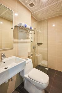 La salle de bains est pourvue de toilettes, d'un lavabo et d'une douche. dans l'établissement ibis budget Singapore Emerald, à Singapour