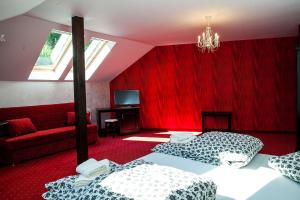 1 dormitorio con 2 camas y pared roja en Am Goldberg, en Sighişoara