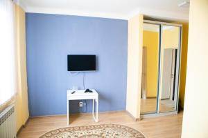 um quarto com uma parede azul e um espelho em Sad Dolgoletiya Hotel em Aqtöbe