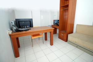 Zimmer mit einem Schreibtisch, einem Computer und einem Stuhl in der Unterkunft Super OYO 1678 Jati Exclusive Homestay in Bengkulu