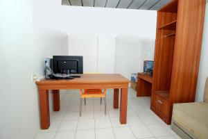 a desk with a computer and a chair in a room at Hotel O Jati Exclusive Homestay in Bengkulu