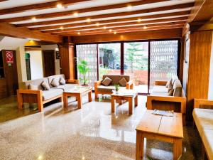 a living room with couches and tables and windows at Hotel Central Bhaktapur in Bhaktapur