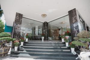 Ban Me Central Hotel في بون ما توت: مبنى به درج وبه نباتات خزفية