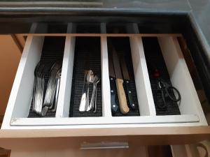a drawer filled with utensils in a cabinet at Restful 3BR Hillside Duplex House in Baguio