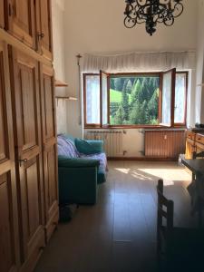 een woonkamer met een bank en een raam bij casa della neve in Foppolo