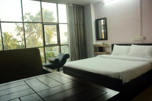 a hotel room with two beds and a window at MALAPPURAM RESIDENCY in Malappuram