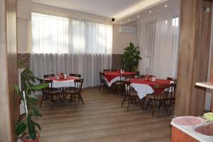 a dining room with red tables and chairs at Family Hotel Chris in Sveti Vlas