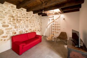 a living room with a red couch and a tv at Mulberry Stonehouse in Primošten