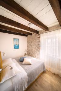 a bedroom with a bed and a brick wall at Mulberry Stonehouse in Primošten
