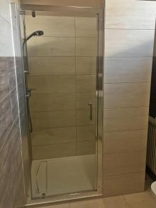 a shower with a glass door in a bathroom at 3Rooms in Kraków