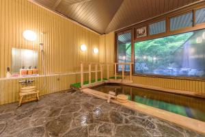 a room with a swimming pool in a house at 료칸 여명 旅館 黎明 Ryokan Reimei in Yufuin
