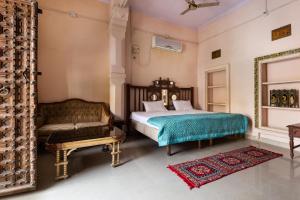 a bedroom with a bed and a couch at Heritage Gouri Haveli in Jodhpur