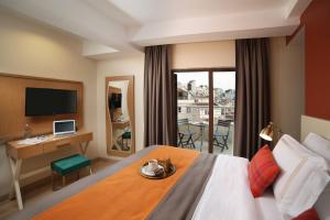 une chambre d'hôtel avec un lit, un bureau et une télévision dans l'établissement The Fox Hotel, à Istanbul