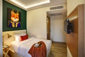 a bedroom with a bed and a painting of a cat at The Fox Hotel in Istanbul