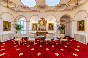 une salle à manger avec des tables et des chaises sur un tapis rouge dans l'établissement Hotel Imparatul Romanilor, à Sibiu