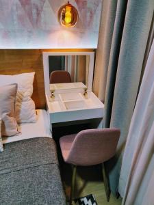 La salle de bains est pourvue d'un lavabo et d'une chaise à côté d'un lit. dans l'établissement Apartment A5 Lux, à Jahorina