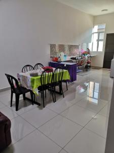 uma cozinha e sala de jantar com mesa e cadeiras em Homestay An-nur em Alor Setar