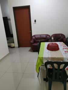 uma sala de estar com uma mesa e um sofá em Homestay An-nur em Alor Setar