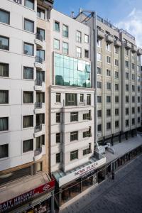 ein hohes weißes Gebäude mit einem Glasfenster in der Unterkunft Nova Plaza Boutique Hotel & Spa in Istanbul