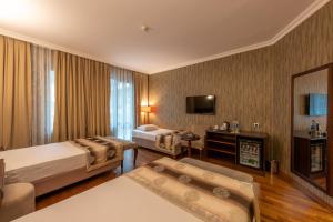 een hotelkamer met 2 bedden en een televisie bij Nova Plaza Boutique Hotel & Spa in Istanbul