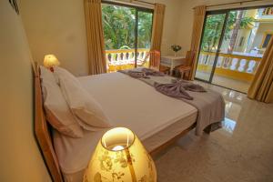 a bedroom with a bed and a window and a table at Primavera Holiday Homes-GOA-CANDOLIM BEACH WITHIN 300 MTRS-GOAN FAMILY HOSPITALITY in Candolim +258 photos