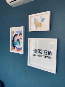 three framed pictures on a blue wall with the words intention to wisdom at CURIOCITY Green Point in Cape Town +64 photos