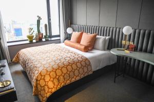 a bed with a white bedspread and pillows in a bedroom at Maison Glad Jeju in Jeju