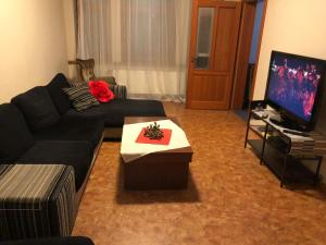 sala de estar con sofá negro y TV en Capital Riga Apartment - Dzirnavu Street, en Riga