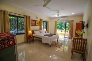 a bedroom with a bed and some windows at Primavera Holiday Homes in Candolim