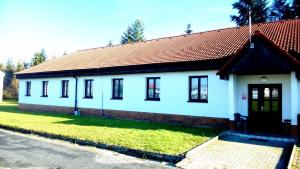 ein kleines weißes Haus mit einem roten Dach in der Unterkunft Penzion Janovice in Janovice nad Úhlavou